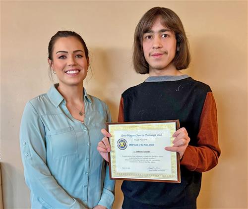  Kenmore West guidance counselor poses with Kenmore West student holding award.